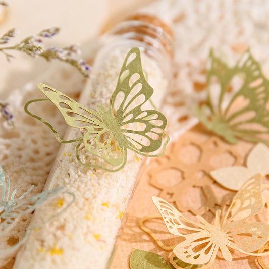Green paper butterfly die cuts propped on glass bath salt tubes