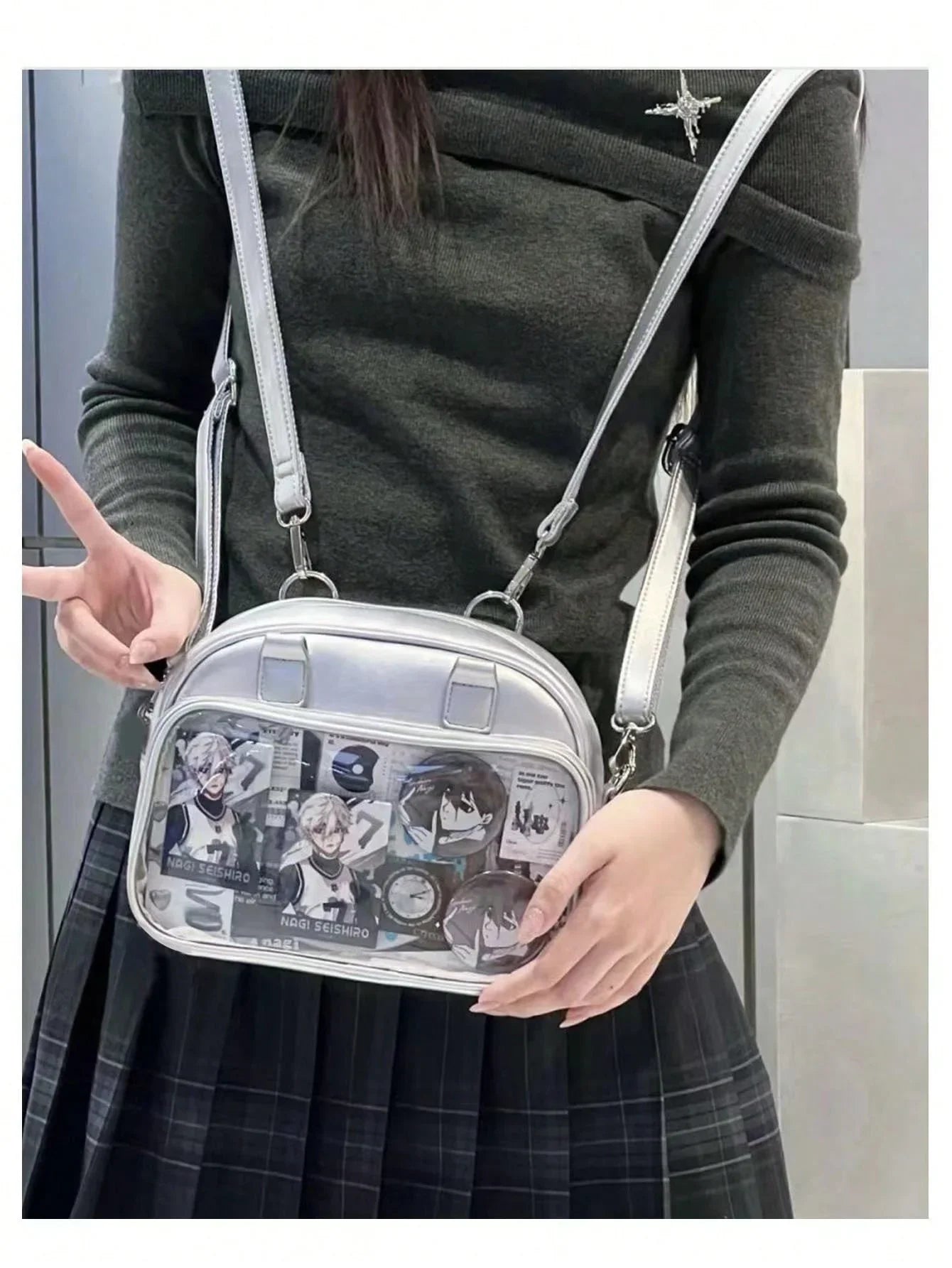 silver metallic mini ita bag crossbody with clear window showing anime cards and pins worn style