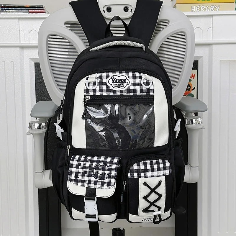  Black and white Miusi ita backpack on white chair, front view