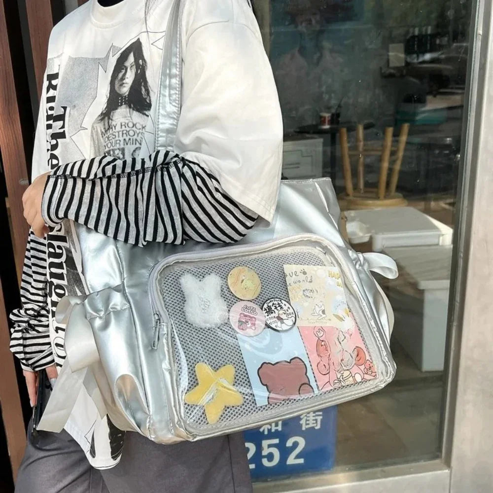 Silver metallic glossy ita bag tote with a large rectangular clear display window and side bow details