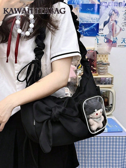 Black bow ita bag worn crossbody with plushie in window