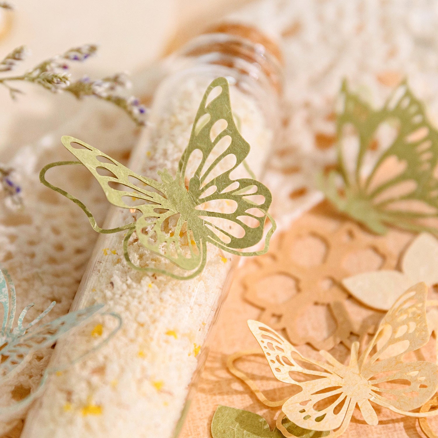 Green paper butterfly die cuts propped on glass bath salt tubes
