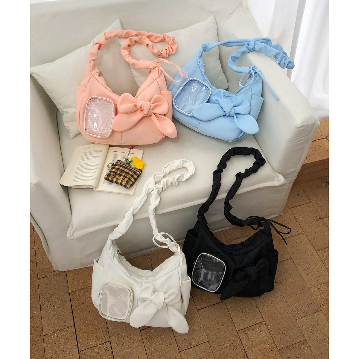 All four colourways — white, black, blue, pink — on sofa