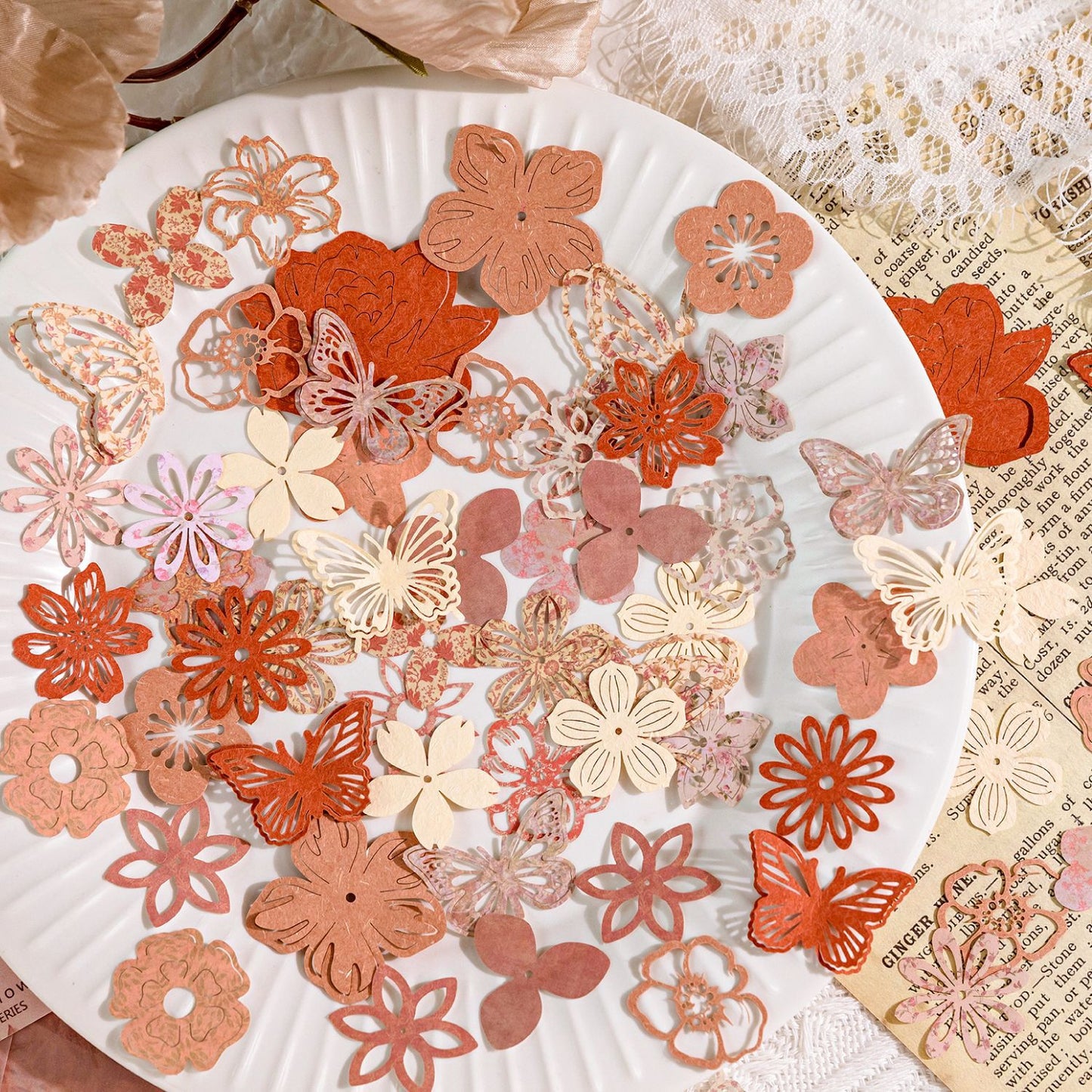 Terracotta and blush paper flowers and butterflies on white plate