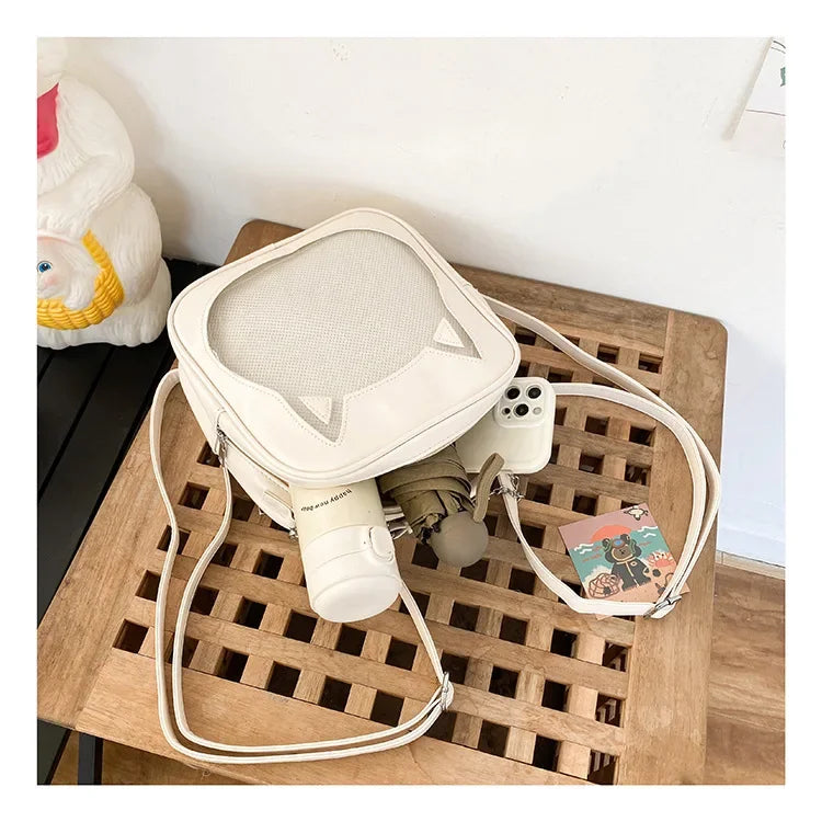 Internal view of the cat ear ita bag holding a 500ml water bottle, a folding umbrella, and an iPhone to show storage capacity.