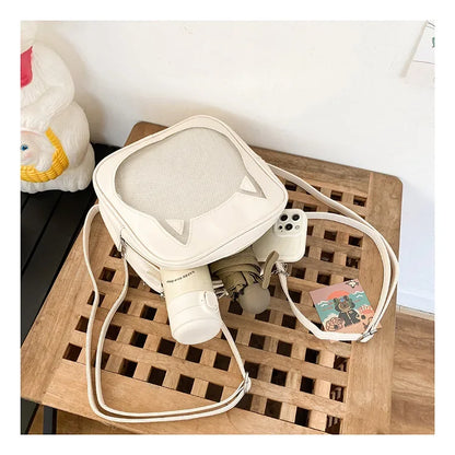 Internal view of the cat ear ita bag holding a 500ml water bottle, a folding umbrella, and an iPhone to show storage capacity.