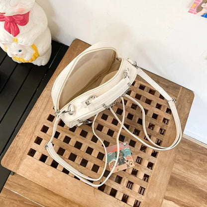 Rear view of the cream cat ear bag showing 3-way convertible strap D-rings and reinforced top handle