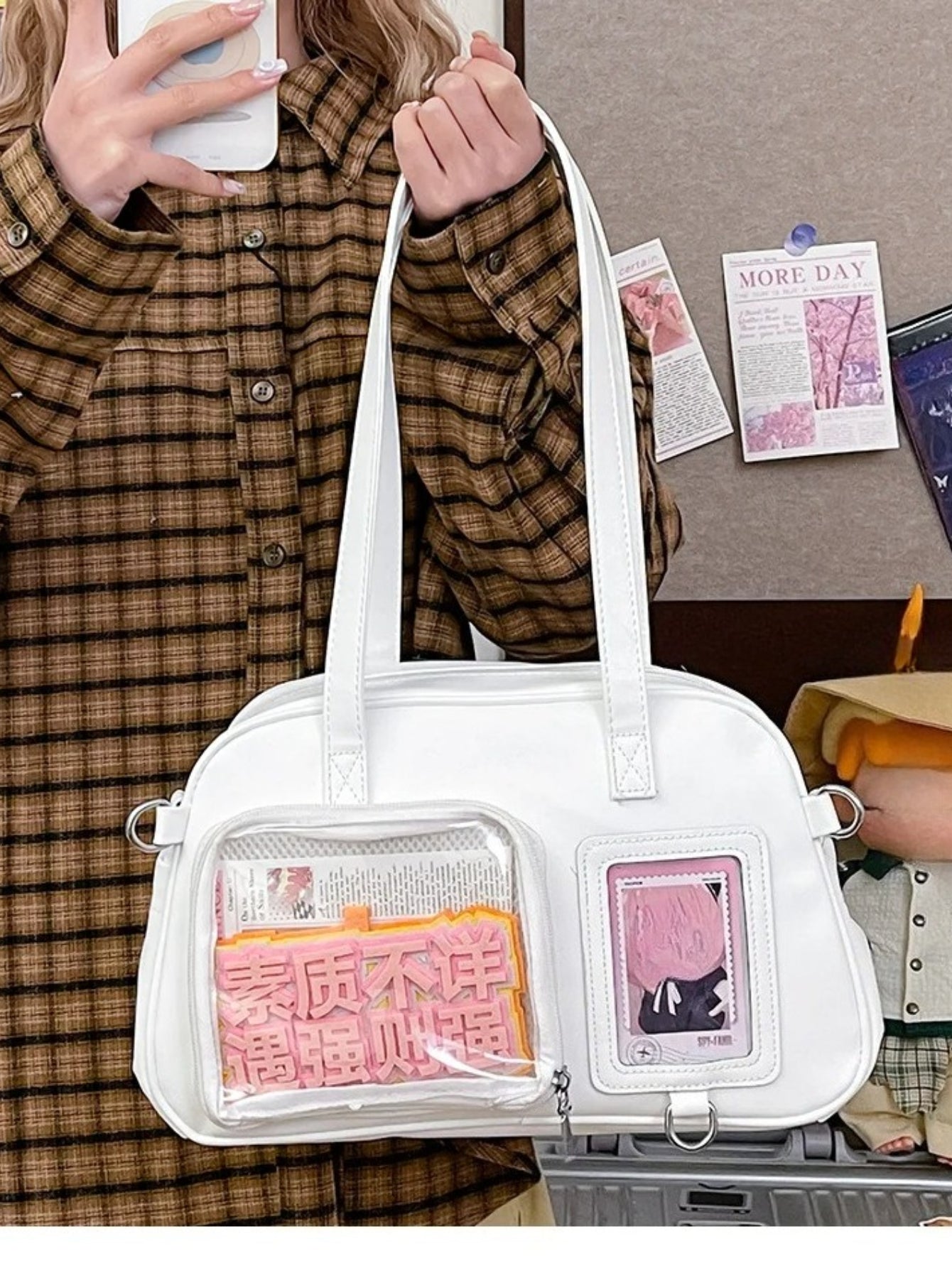 White ita bag with transparent windows and brown plaid shirt
